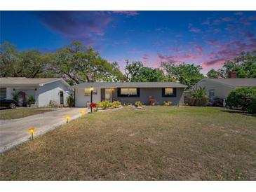 Charming home featuring a well-manicured front yard and inviting exterior lighting at 1655 Owen Dr, Clearwater, FL 33759