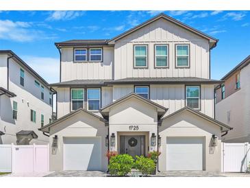 Beautiful three-story home with white siding, a two-car garage and manicured landscaping at 1725 Massachusetts Ne Ave, St Petersburg, FL 33703
