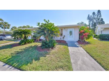 Charming home featuring lush landscaping, green grass, and an inviting entrance at 2202 Clubhouse Dr # 174, Sun City Center, FL 33573