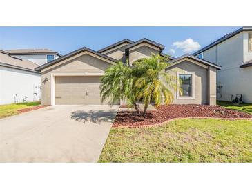 Charming single-Gathering home featuring a well-maintained lawn and a two-car garage at 11922 Winterset Cove Dr, Riverview, FL 33579