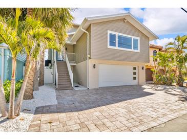 Two-story home featuring a neutral color palette, a two-car garage, and mature landscaping at 12312 Lagoon Ln, Treasure Island, FL 33706