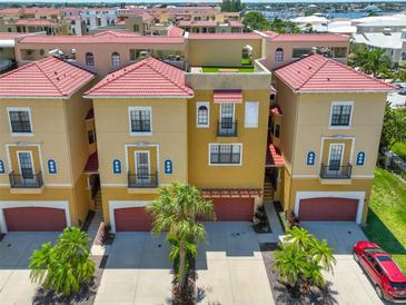 Charming townhomes with red tile roofs, private garages, and lush palm tree landscaping at 6407 Mayra Shores Ln, Apollo Beach, FL 33572
