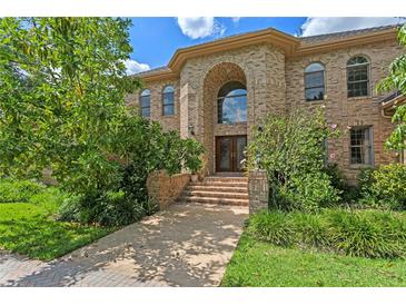 Stately brick home with a grand arched entryway and well-manicured landscaping at 1203 Parrilla De Avila, Tampa, FL 33613