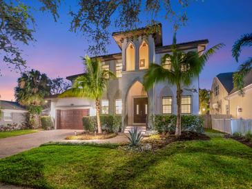 Elegant two-story home featuring lush landscaping, a spacious driveway, and exquisite architectural details at 150 Chippewa Ave, Tampa, FL 33606