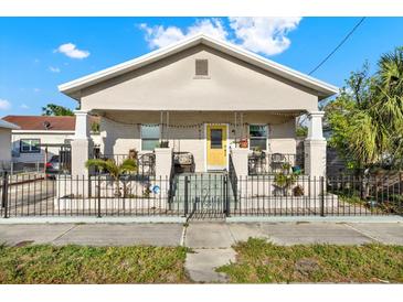 Charming single-story home with a cozy front porch and decorative wrought iron fence at 2818 N 19Th St, Tampa, FL 33605