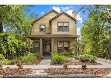 Charming two-story home featuring a covered front porch, lush landscaping, and a classic design at 6007 N Suwanee Ave, Tampa, FL 33604