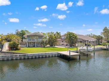 Waterfront home with dock, boat lift, and lush landscaping offers prime coastal living on a sunny day at 3901 Pompano Se Dr, St Petersburg, FL 33705