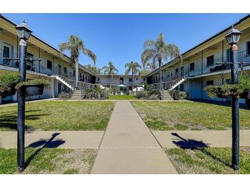 A well-maintained courtyard featuring lush green grass, palm trees, and a central walkway at 525 9Th N Ave # 2, St Petersburg, FL 33701