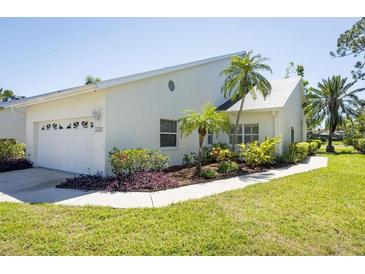 Charming single-story home featuring a well-maintained lawn, mature landscaping, and an attached two-car garage at 6208 Country Club Way, Sarasota, FL 34243