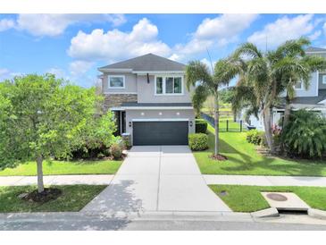 Charming two-story home with stone accents, a well-maintained lawn, and a convenient two-car garage at 6518 Salt Creek Ave, Apollo Beach, FL 33572