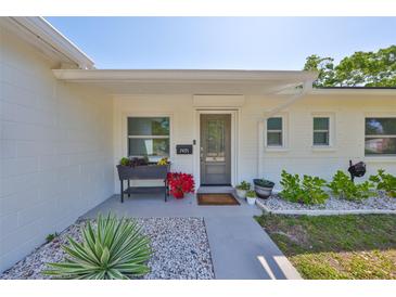 Inviting front entrance with decorative landscaping and a freshly painted exterior, and neutral colors at 7491 Cedar Ne St, St Petersburg, FL 33702