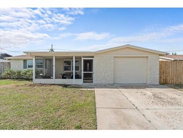 Charming single-story home features a stone facade, screened porch, and attached garage at 3748 Redwood Dr, Holiday, FL 34691