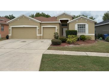 Tan single-Gathering home with a well-maintained lawn and a two-car garage at 11318 Laurel Brook Ct, Riverview, FL 33569