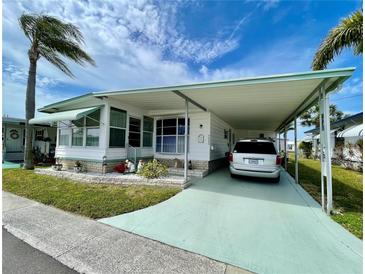 Charming single-story home with carport, awnings, well-maintained landscaping, and sunny Florida skies at 34222 Canal N Dr, Pinellas Park, FL 33781