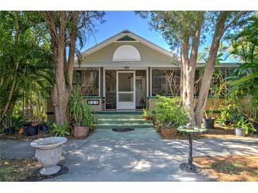 Charming home with lush landscaping, a screened porch, and a inviting entryway at 921 24Th N Ave, St Petersburg, FL 33704