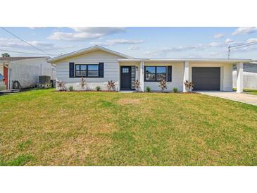 Charming single-story home featuring a well-maintained lawn, attached garage, and a welcoming front entrance at 13617 Frances Ave, Hudson, FL 34667