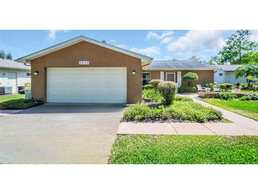 Charming single-story home featuring a well-maintained lawn and attached two car garage at 2814 Lomond Dr, Palm Harbor, FL 34684