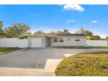 Charming single-story home featuring a well-maintained yard and attached garage at 8801 Sunlit Cove Ne Dr, St Petersburg, FL 33702