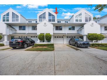 Attractive townhome exterior with a one car garage, manicured landscaping, and a clean driveway at 14649 Seminole Trl # 5, Seminole, FL 33776