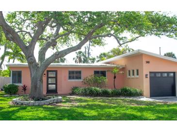 Charming single Gathering home featuring lush landscaping, mature trees and a one car garage at 340 81St Ave, St Pete Beach, FL 33706