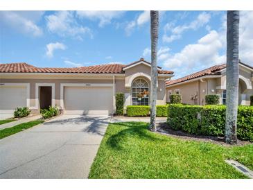 Charming home with red tile roof, well-manicured lawn, and attached two-car garage at 3885 Timber Ridge Ct, Palm Harbor, FL 34685