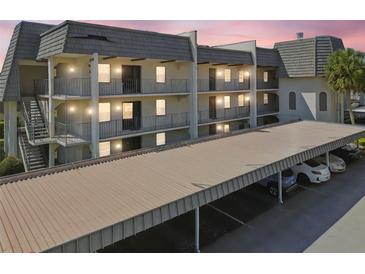 A charming multi-level condominium complex with covered parking and balconies at sunset, offering convenient and stylish living at 8703 Bardmoor Blvd # 203, Seminole, FL 33777