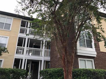 An attractive condo community featuring brick and siding, white railings, and mature landscaping at 10114 Winsford Oak Blvd # 517, Tampa, FL 33624