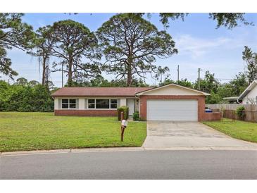 Charming single-story brick home featuring a two-car garage, manicured lawn, and mature trees at 14006 79Th Ave, Seminole, FL 33776