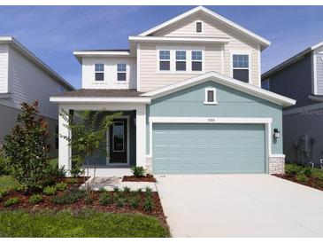 Charming two-story home featuring a two-car garage and beautifully landscaped front yard at 3319 Guanabana Xing, Wesley Chapel, FL 33543