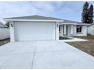 Newly constructed home featuring a large two-car garage and freshly poured concrete driveway at 3329 Roxbury Dr, Holiday, FL 34691
