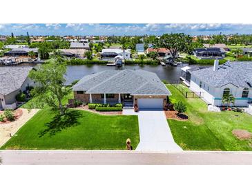 Beautiful waterfront home with lush green lawn and well-manicured landscaping at 829 Golf Island Dr, Apollo Beach, FL 33572