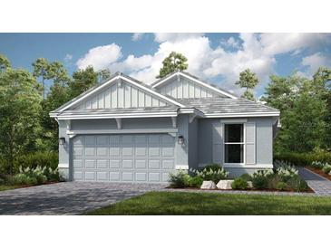 Charming one-story home featuring a two-car garage and a mix of vertical and horizontal siding details at 29536 Zupetta Ln, Wesley Chapel, FL 33545