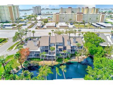 Aerial view showing the building near the waterfront, surrounded by palm trees and a scenic pond at 4611 Duhme Rd # 1A, St Petersburg, FL 33708