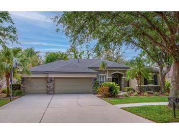 Lovely single-story home boasts a three-car garage and meticulously landscaped front yard at 6205 Ibispark Dr, Lithia, FL 33547