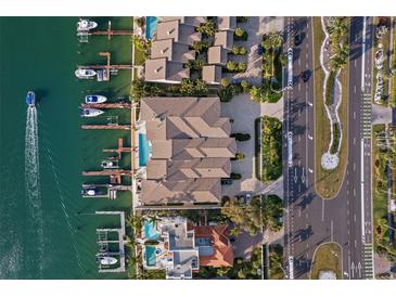 Stunning aerial view of waterfront homes with private docks and a luxurious swimming pool at 830 Pinellas Bayway S, St Petersburg, FL 33715