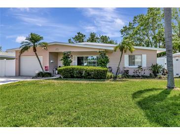 Charming single-story home featuring a well-manicured lawn, tidy landscaping, and lovely curb appeal enhanced by palm trees at 940 43Rd Ne Ave, St Petersburg, FL 33703