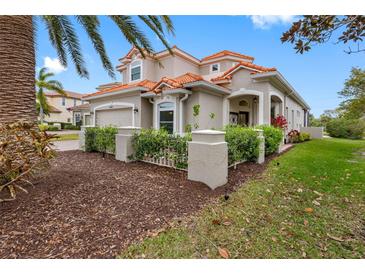 Charming home featuring a red tile roof and tropical landscaping at 9897 Sago Point Dr, Seminole, FL 33777