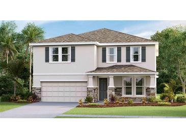 Charming two-story home featuring stone accents, a two-car garage, and complemented by a well-maintained lawn and landscape at 10589 Farm Hill Ave, Land O Lakes, FL 34638
