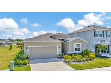 Well-manicured front exterior with neutral color palette, charming landscaping, and inviting curb appeal at 16633 Mooner Plank Cir, Wimauma, FL 33598