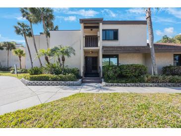 Inviting two-story condo with mature landscaping, tropical foliage, and a private balcony overlooking lush front yard at 2205 Belleair Rd # A24, Clearwater, FL 33764