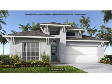 Inviting exterior of home featuring a two-car garage, modern design, and beautiful landscaping at 406 Sun Chaser Dr, Nokomis, FL 34275