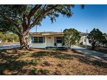 Charming single-story home with a large tree, a covered porch, and a well-maintained front yard at 7051 Dartmouth N Ave, St Petersburg, FL 33710