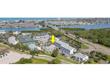 An aerial view of condo community, featuring tennis courts, waterway, and surrounding neighborhood at 14800 Walsingham Rd # 301, Largo, FL 33774