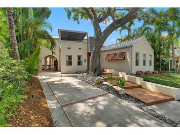 Charming home exterior featuring a lush garden, mature trees, and a welcoming walkway at 326 16Th Ne Ave, St Petersburg, FL 33704