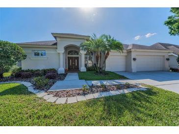 Stunning single-story home showcasing a well-manicured lawn and a double-door entrance at 4693 Aylesford Dr, Palm Harbor, FL 34685