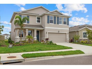 Charming two-story home with a well-maintained lawn, neutral paint, a two-car garage, and decorative blue shutters at 17923 Cantarina Cv, Bradenton, FL 34211
