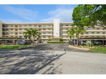The building has a light exterior with a parking garage and many balconies under a mostly clear sky at 8198 Terrace Garden N Dr # 411, St Petersburg, FL 33709