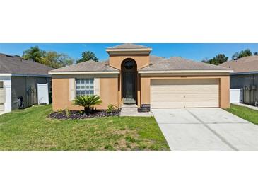 Charming single Gathering home with a two-car garage, lovely landscaping, and a well-manicured front lawn at 26850 Middleground Loop, Wesley Chapel, FL 33544