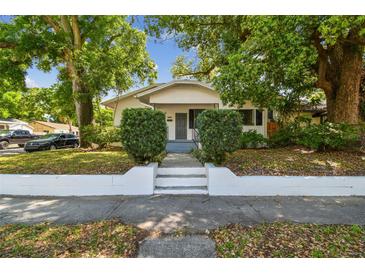 Charming bungalow-style home with lush trees, manicured shrubs, and a welcoming front entrance at 3411 N 12Th St, Tampa, FL 33605