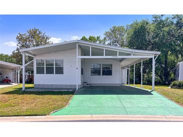 Charming single story home with a covered parking area, well-maintained lawn, and inviting curb appeal at 34150 Estates Ln, Wesley Chapel, FL 33543